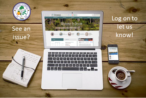 Picture of laptop and phone on a table with coffee and a notpad. 